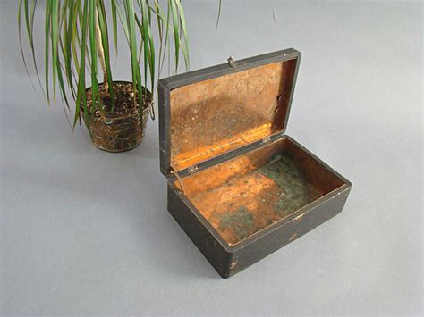 This wooden box is lined with sheet metal, and the lid is held